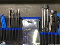 First image of precision spudgers, pry tools, tweezers, and accessories organized in roll-up pouch.