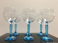 Six Bombay Sapphire balloon style glasses with blue swirl stems and octagonal bases