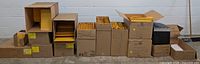 Multiple cardboard boxes in a row filled with various sizes of kraft bubble mailers and padded envelopes.
