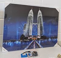 Front view of the framed LED lighted picture showing the Petronas Twin Towers at night with blue LED lights illuminating the towers.