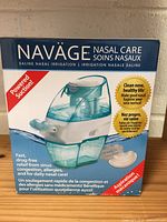 Box and product visible showing Naväge Nasal Care saline nasal irrigation system with powered suction and instructions in English and French.
