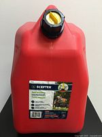 Front view of red plastic gas can showing Scepter label, black cap with yellow child-proof vent and safety information.