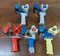 Top view of all five tape dispensers showing colors and handle designs.