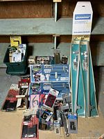 Wide view showing a variety of locks, security guards, kick plates, door knobs, and assorted hardware arranged on shelves and floor.