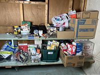 Overview photo showing multiple boxes and containers on shelves with various plumbing and electrical parts including boxes marked spaghetti (reused for storage) and plumbing and electrical hardware scattered and packed.