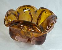 Front angled view of the chalet style glass bowl showing ruffled rim and color gradient of gold and pink hues.