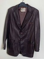 Front view of brown leather sports jacket showing overall condition and design.