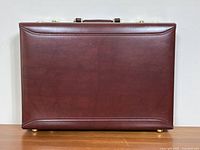 Front view showing smooth burgundy leather surface and protective feet on bottom