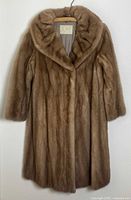 Front view of the vintage mink fur coat hanging on a hanger, showing collar and full body length.
