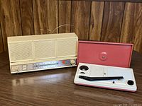 Westinghouse AM/FM radio next to Selfix portable turntable with lid open on wood surface.