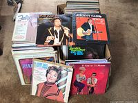 Two cardboard boxes filled with vinyl LP jackets showing front row of Felix Leclerc, Tom Jones, Johnny Cash, Colette Renard, Ti-Gus et Ti-Mousse
