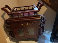 Full side view of the wooden bar cart with removable tray top on top and cabinet doors below.