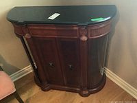 Front view of the wood bar credenza showing stone top, carved wood details, double doors with metal pulls, and glass side panels.