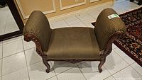 Front and side views of French Country style bench seat showing patterned upholstery, carved wooden legs and armrests