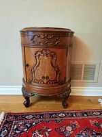Front view of semi-circular cabinet showing inlaid veneer and carved mounts