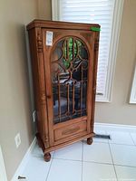 Front view of wooden china cabinet with decorative glass door