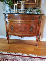 Front view of dresser showing three drawers, marble top and ormolu accents
