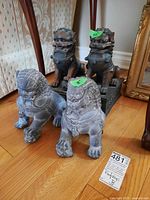 Four Foo Dog statues together on wood floor showing size and condition.