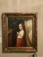 Full view of framed print hung on wall showing young girl in rustic setting