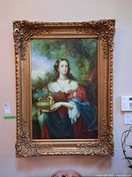 Full view of ornate gold‐tone framed canvas print showing portrait of woman holding vessel