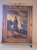 Full view of framed print showing man on white horse with ornate gold frame