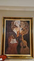 Front view of framed print artwork featuring a woman holding a guitar.