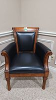 Front view of leather upholstered wood office chair showing seat, back and carved front legs