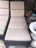 Full top view of beige cushioned rattan style lounger chair, shows removable cushions and seat area.