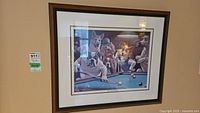Framed print of dogs around a pool table playing pool, dark wood frame, white mat, wall hung