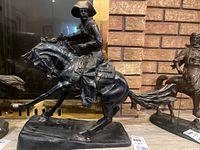 Front three-quarter view of cowboy on horse, mounted on rectangular base