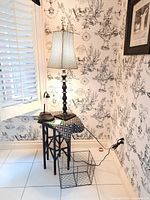 Photo showing the wood accent table with black wire basket underneath, 33.5-inch tall table lamp with checkered shade on top, and small black desk lamp