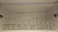 Shelf with inverted stemware in clusters of small, medium, and tall glasses