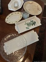 Porcelain and glass serving dishes arranged on table showing various shapes and decorative patterns