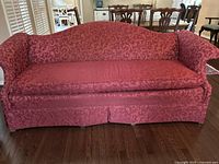 Front-facing view of traditional red damask fabric sofa showing the full seating area, rolled arms, and skirted base.