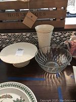 Photo showing Lenox footed cake plate, cream-colored 9-inch vase with gold trim, and clear crystal bowl with diamond cut pattern.
