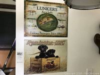 Four metal wall plaques arranged on a wall, showing fishing and hunting themes