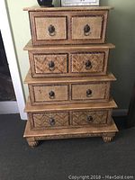 View of the entire four tier graduating lingerie chest with rush front drawers, showing the graduating sizes, woven rush drawer fronts, and bun feet.