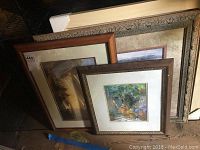 Four framed prints stacked together showing variation in frame style and size