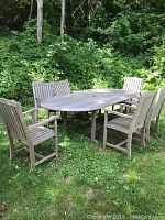 Five-piece teak outdoor dining set from front view including oval table and chairs