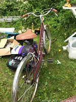 Full side and rear view of the Ross Eurotour bicycle showing maroon frame, brown leather saddle, and rear fender.