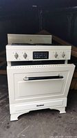 Front view of the white Heartland Legacy range showing the oven door, control knobs and the electronic display panel.