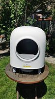 Front view of white Peetree self-cleaning cat litter box showing circular entry opening.