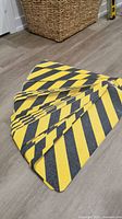 40 adhesive grip strips with yellow and black diagonal stripes laid out and overlapping showing front non-slip surfaces