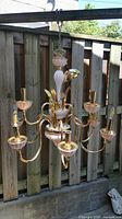 Full view of vintage chandelier showing gold metal frame and multiple pink glass elements, eight light sockets with matching glass cups.