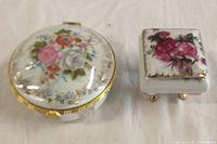 Top view of both vintage jewelry dishes showing floral designs and gold accents