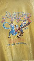 Front of yellow Avatar The Last Airbender T-shirt with graphic print of characters and series logo.