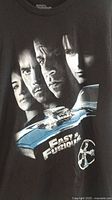 Front view of black XL Fast & The Furious T-shirt showing character faces and car graphic.
