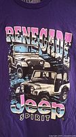 Front view of purple T-shirt with Jeep Renegade Spirit graphic showing two Jeep vehicles and logo text.