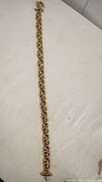 Full length view of the gold tone ladies necklace laid flat showing the entire length and link design