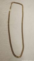 Full view of the gold tone chain necklace showing its entire length and clasp